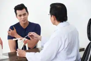 an orthopedic surgeon explaining to a patient about shoulder fracture treatment