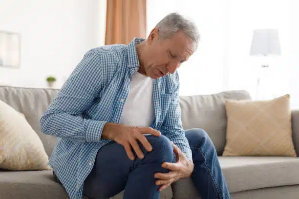 Old Man holding his knee feeling of intense pain cause by Meniscus 