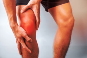 Man holding his knee feeling of intense pain caused by arthritis of the knee joint.