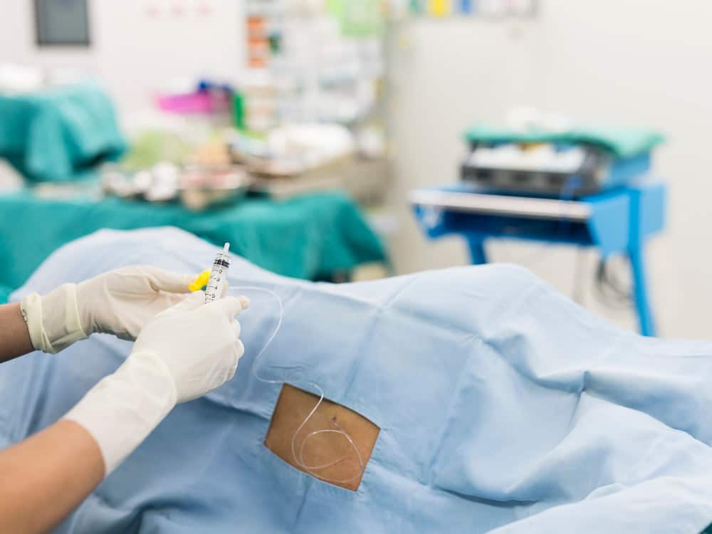 Surgeon doing Lumbar Sympathetic Block to the patient.