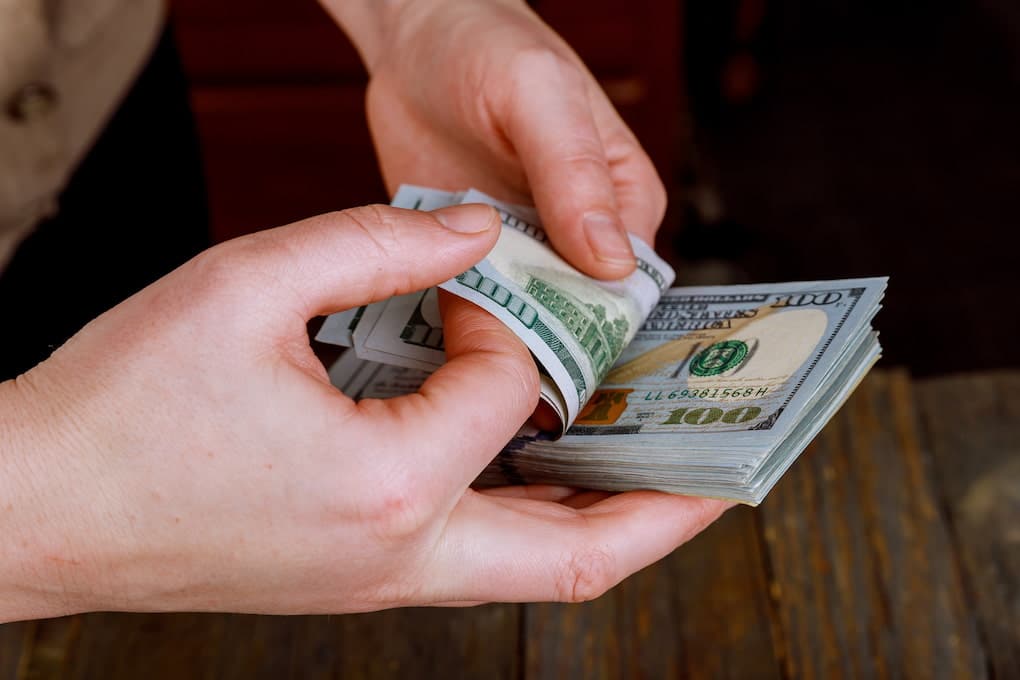 Patient counting money to pay hospital bills in cash.