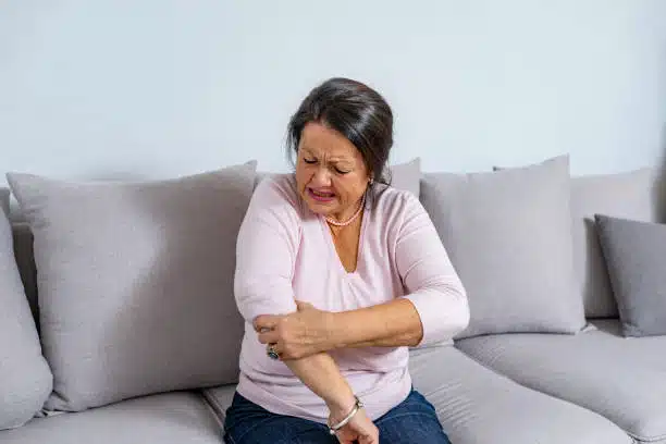 Senior woman suffers from Arthritis feeling intense pain of the elbow.