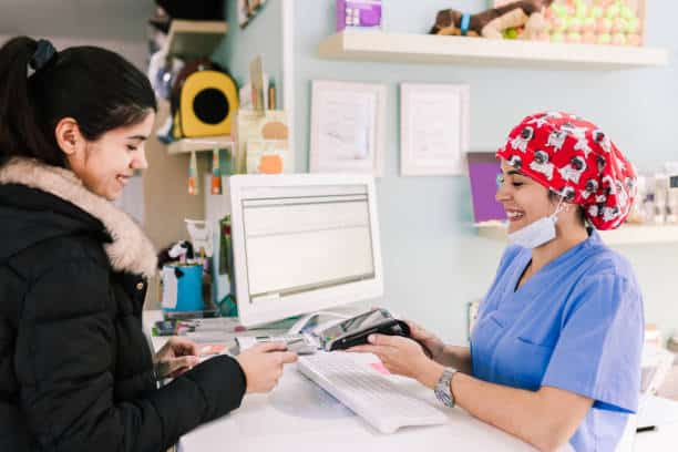 Patient paying her surgery bill with own debit card.