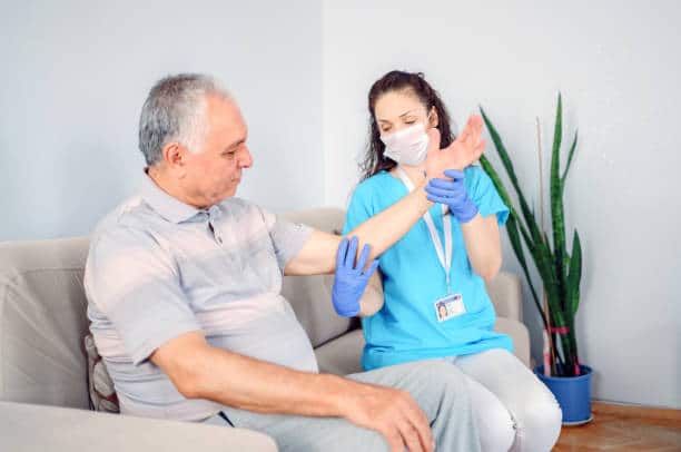 Senior male patient having some elbow examination at surgery center.