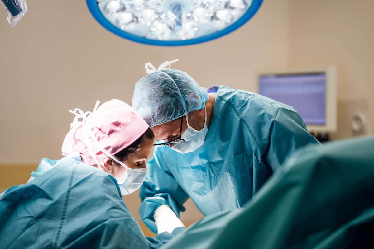 Surgeons having a foot surgery inside the operating room.