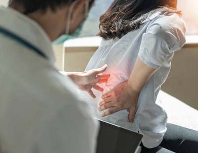 Woman indicating back pain area to specialist