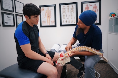 Physician wearing a turban detailing to patient about human spine