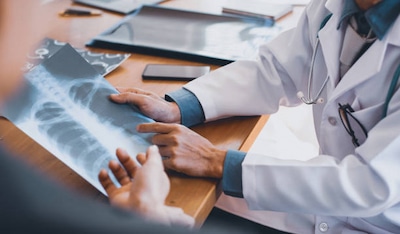 Doctor showing patient Xray images of spine