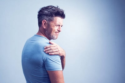 Man holding painful part of his shoulder